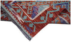 A handmade Afghan Maimana wool kilim runner featuring geometric patterns in red, blue, and orange.