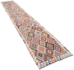 A handmade Afghan Maimana wool runner rug featuring a colorful geometric diamond pattern.