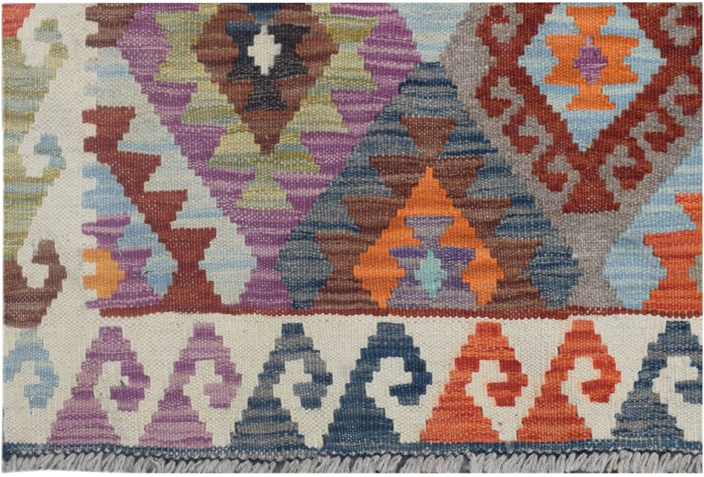 Handmade Afghan Maimana kilim runner featuring a colorful geometric pattern on a cream background.