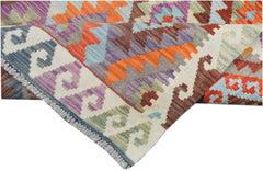 A handmade Afghan Maimana kilim runner featuring vibrant geometric patterns in wool.
