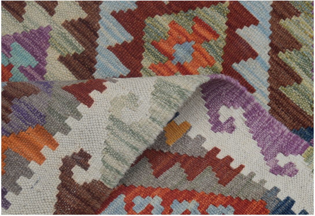 A handmade Afghan Maimana kilim runner featuring a colorful geometric pattern in wool.