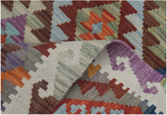 A handmade Afghan Maimana kilim runner featuring a colorful geometric pattern in wool.