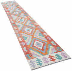 A handmade Afghan Maimana wool runner rug featuring a colorful geometric diamond pattern.