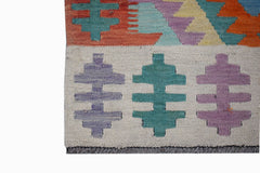 A handmade Afghan Maimana kilim runner featuring geometric patterns in purple, teal, and orange.