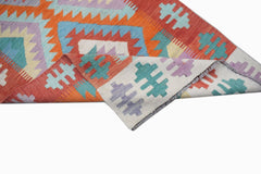A handmade Afghan Maimana kilim runner featuring a geometric pattern in orange, blue, and purple.