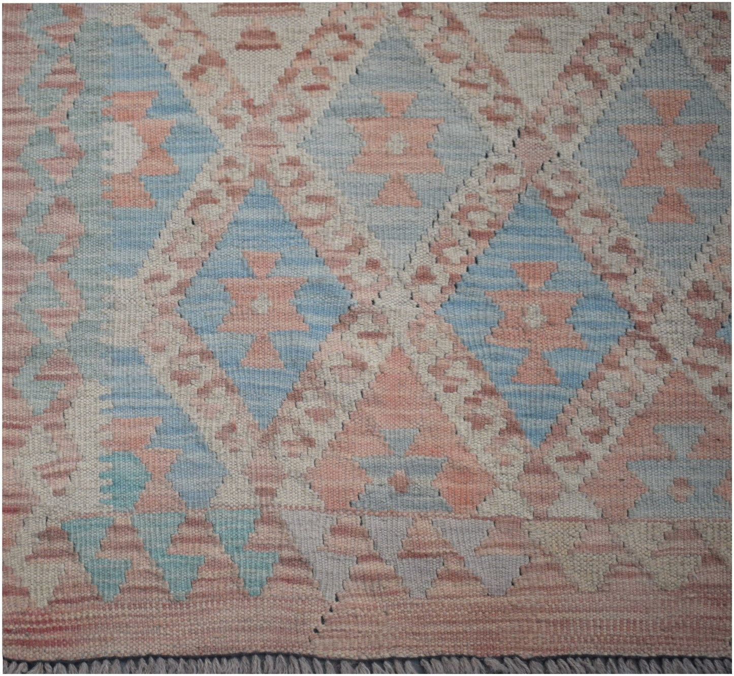 Handmade Afghan Maimana kilim runner featuring a geometric diamond pattern in soft blue and pink.