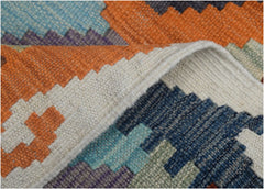 A close-up view of a handmade Afghan Maimana kilim runner featuring geometric patterns in vibrant colors.