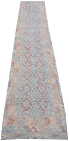 A handmade Afghan Maimana kilim runner featuring a geometric diamond pattern in blue and pink.
