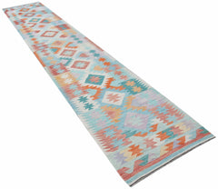 A handmade Afghan Maimana Kilim runner featuring a colorful geometric pattern on a light blue base.