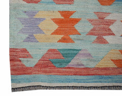 A handmade Afghan Maimana Kilim runner featuring geometric patterns in vibrant, multicolored wool.