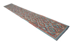 A long, handmade Afghan Maimana Kilim runner featuring a geometric diamond pattern in red and blue.