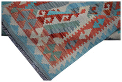 A handwoven Afghan Maimana wool kilim runner featuring a geometric pattern in red and blue.