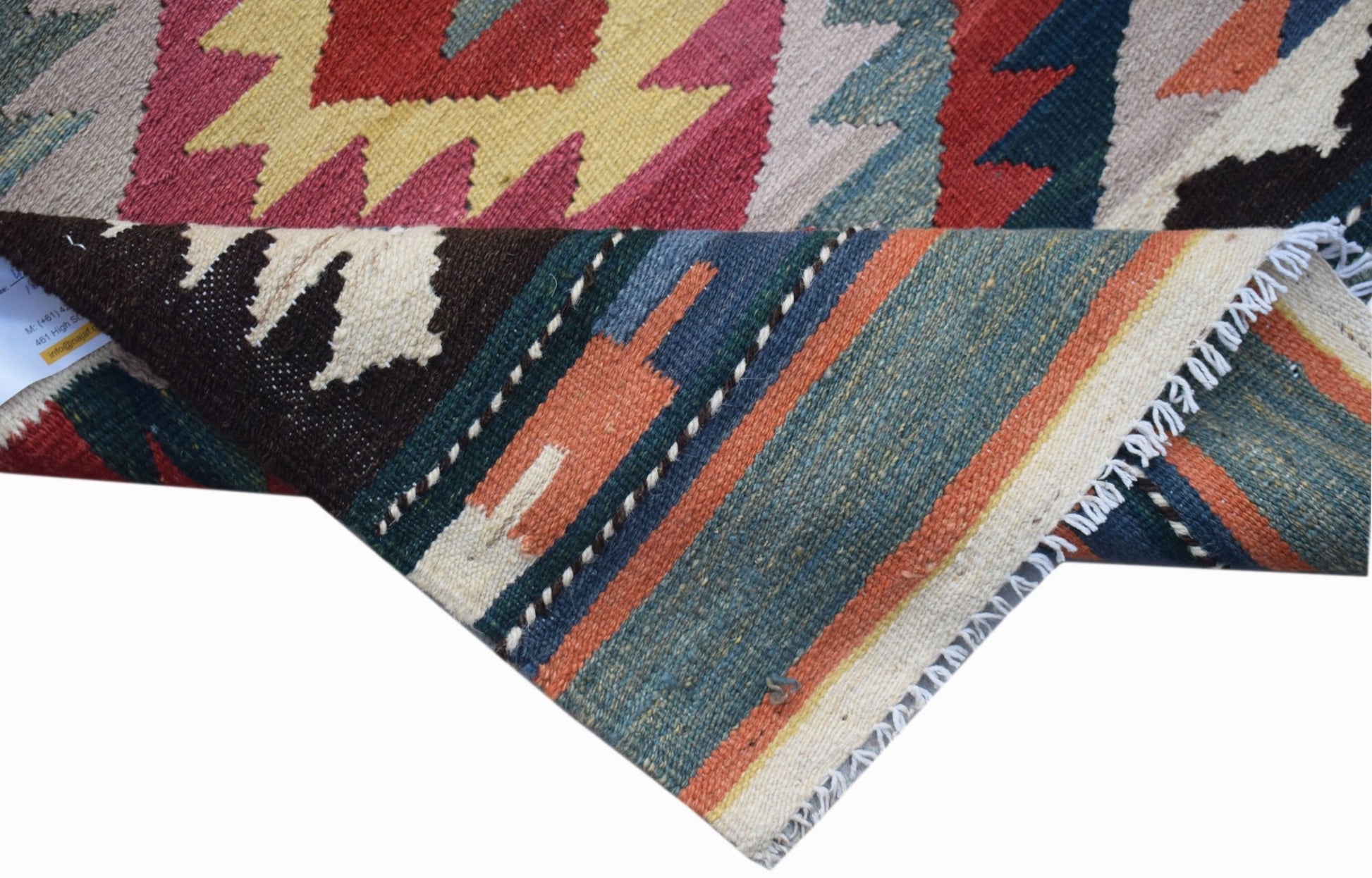 A handwoven Afghan Maimana wool kilim runner featuring geometric patterns in vibrant colors.