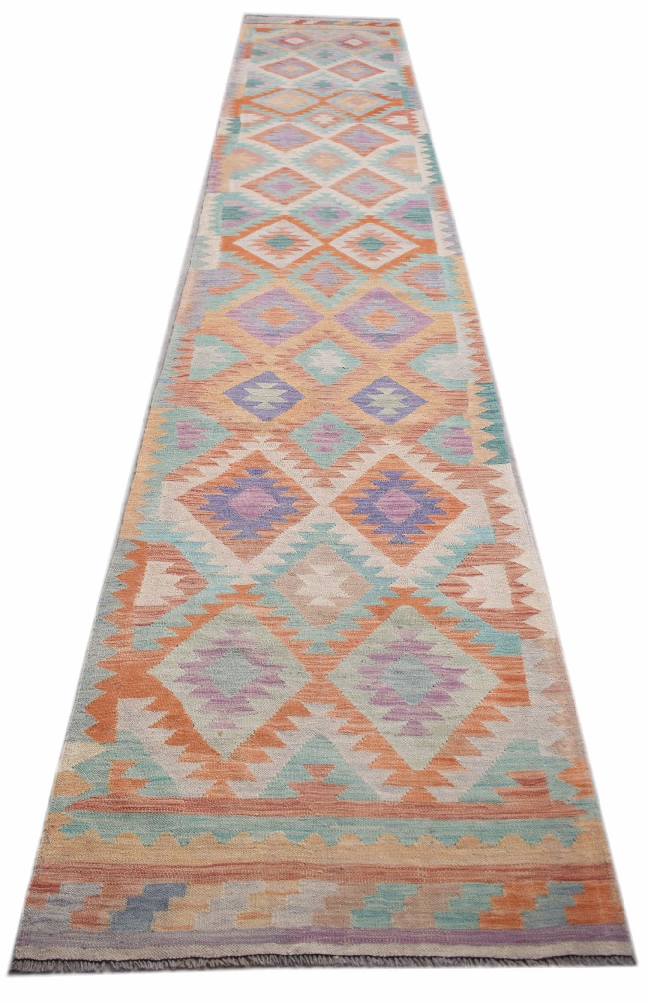 A handmade Afghan Maimana wool runner rug featuring a colorful geometric diamond pattern.