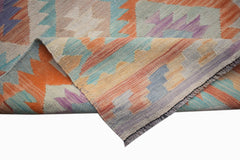 A handmade Afghan Maimana kilim runner featuring a geometric pattern in orange, blue, and purple.