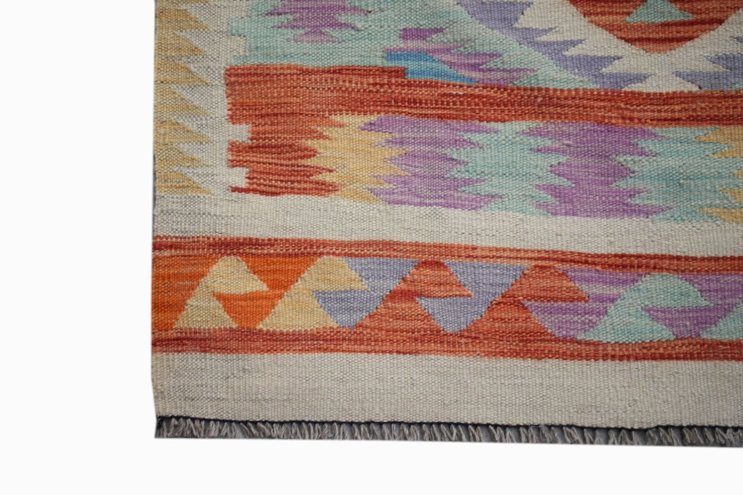 A handmade Afghan Maimana kilim runner featuring geometric patterns in orange, purple, and blue.
