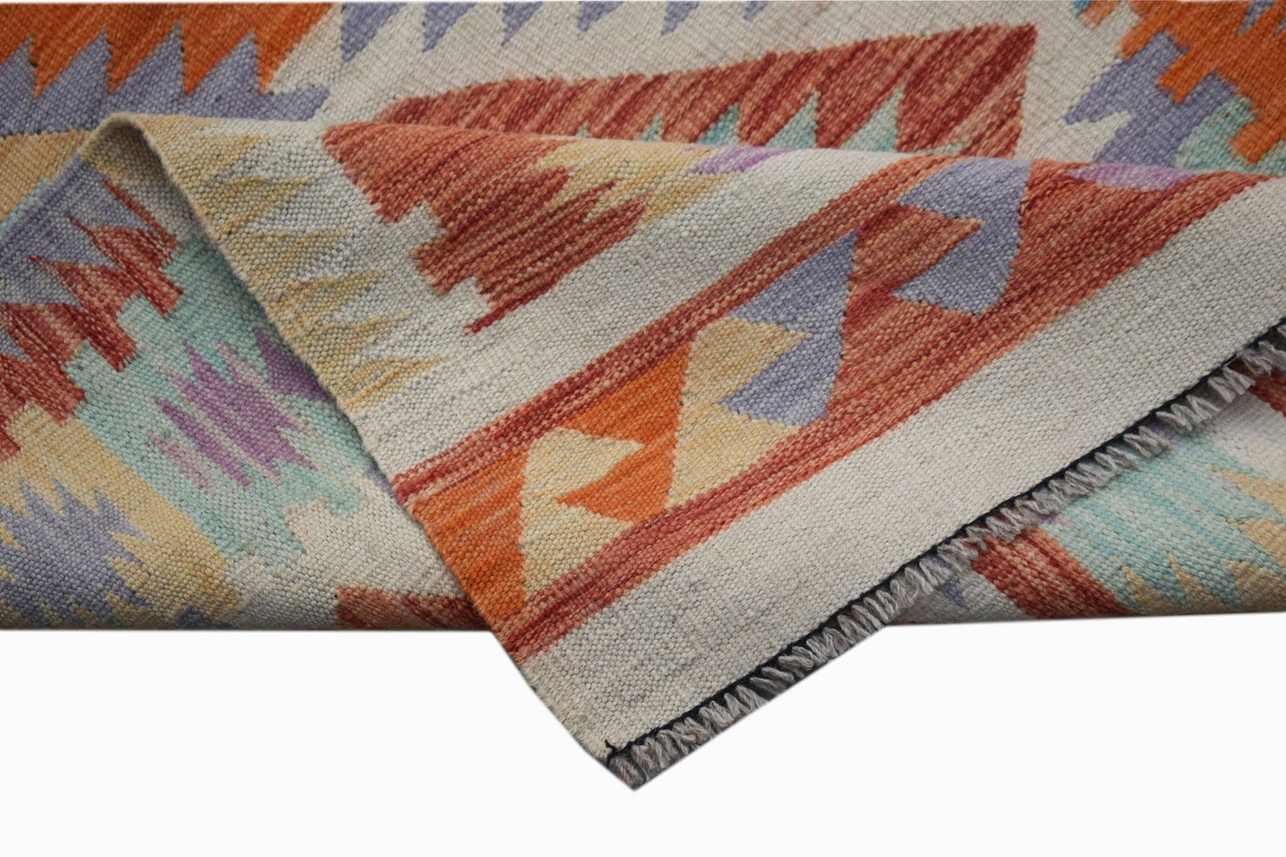 A handwoven Afghan Maimana kilim runner featuring a geometric pattern in orange, blue, and cream.