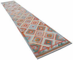 A handmade Afghan Maimana wool runner rug featuring a colorful geometric diamond pattern.
