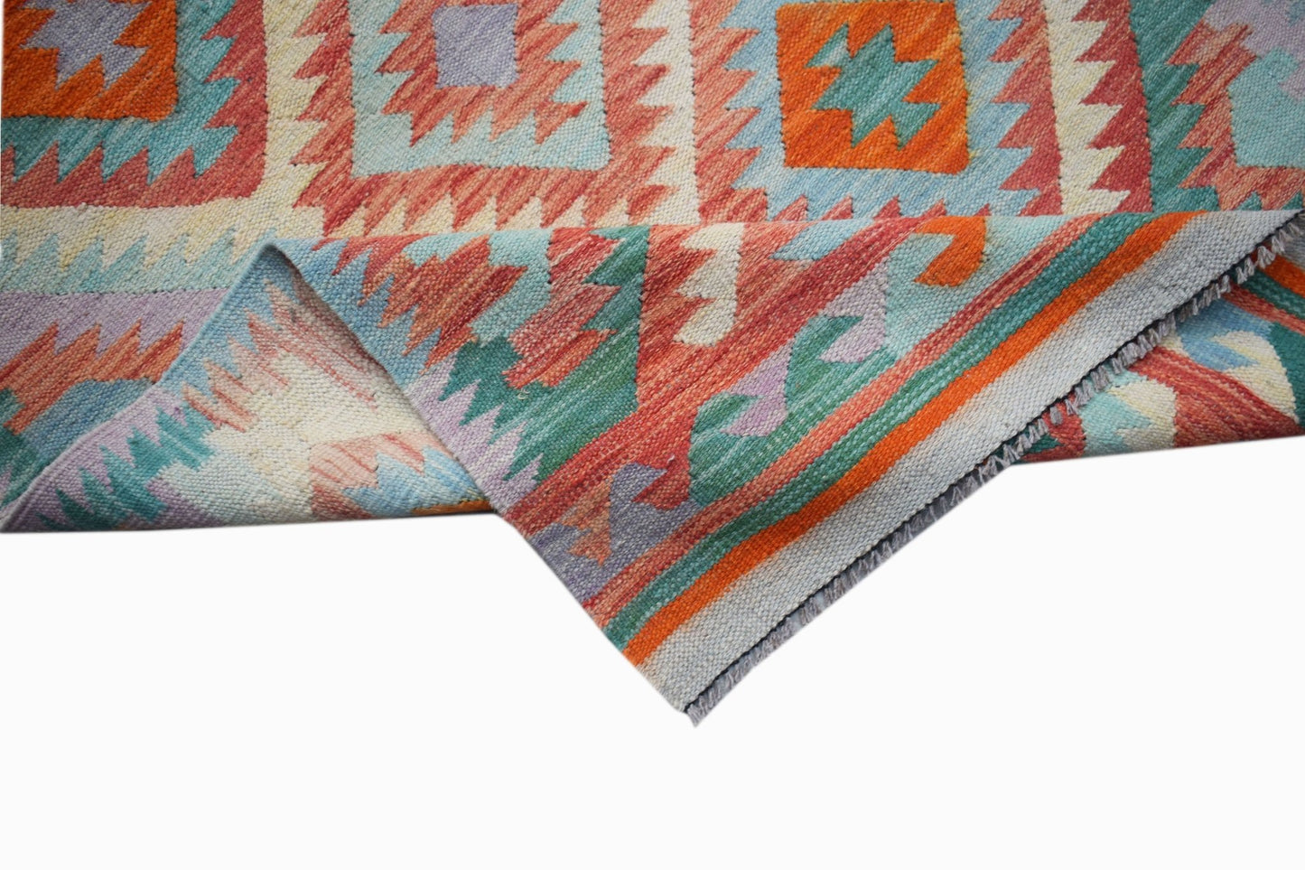 A handmade Afghan Maimana kilim runner featuring a geometric pattern in vibrant wool colors.