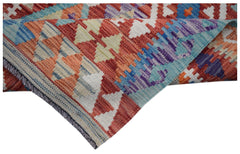 A handwoven Afghan Maimana kilim runner featuring a vibrant geometric pattern in wool.