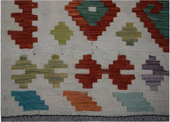 Handwoven Afghan Maimana kilim runner featuring a cream background with colorful geometric motifs.
