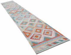 A handmade Afghan Maimana wool runner rug featuring a colorful geometric diamond pattern.