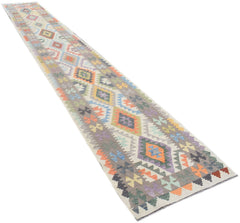 A handmade Afghan Maimana wool runner rug featuring a colorful geometric diamond pattern.