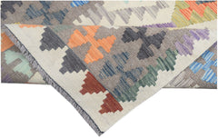 A handmade Afghan Maimana kilim runner featuring a colorful geometric pattern on a wool base.