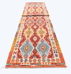 A long, handmade Afghan Maimana wool runner featuring vibrant geometric diamond patterns.