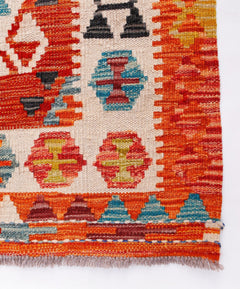Handwoven Afghan Maimana kilim runner featuring geometric patterns in vibrant orange and blue tones.