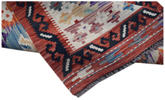 A handwoven Afghan Maimana Kilim runner featuring geometric patterns in rich, vibrant colors.