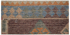 A handmade Afghan Pashm rug featuring a geometric pattern in shades of blue, brown, and orange.