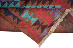 A handmade Afghan Pashm rug featuring a geometric tribal pattern in shades of red, brown, and blue.