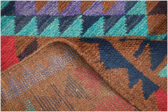 A handmade Afghan Pashm rug featuring a geometric pattern in shades of red, blue, and brown.