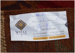 A handmade Afghan Pashm rug featuring a traditional tribal pattern in shades of red and brown.