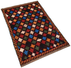 A handmade Afghan Pashm rug featuring a repeating pattern of colorful geometric crosses.