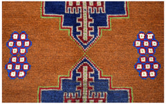 Handmade Afghan Pashm rug featuring geometric blue and red tribal motifs on a brown wool background.