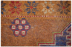 A handmade Afghan Pashm rug featuring a brown wool base with geometric blue and red patterns.