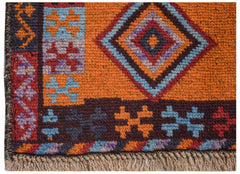 A handmade Afghan Pashm rug featuring a geometric diamond pattern in orange, blue, and dark red.