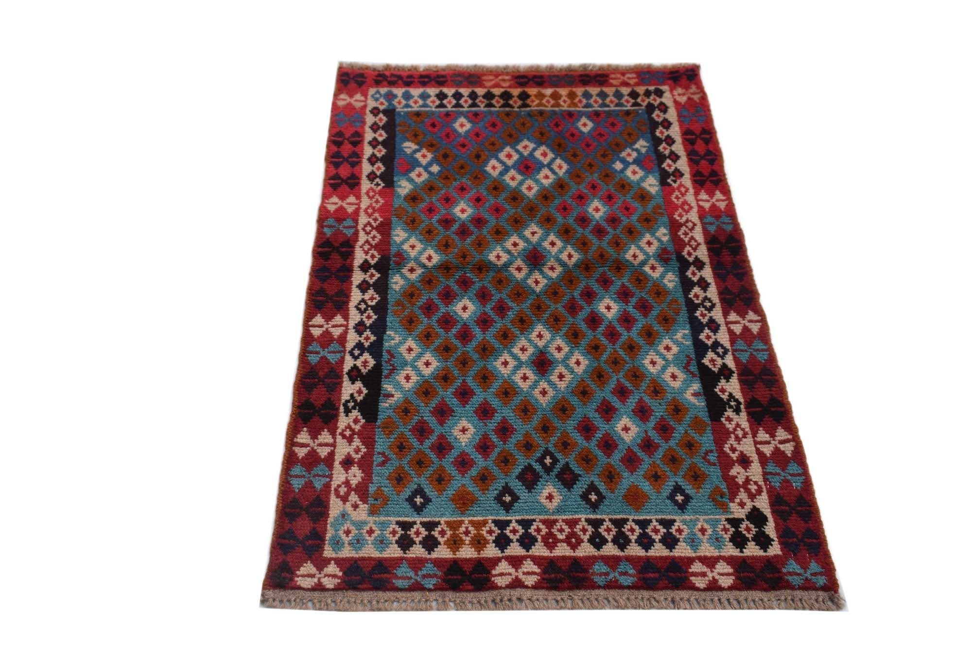 Handmade Afghan Pashm rug featuring a geometric diamond pattern in red, blue, and ivory wool.