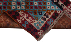 A handmade Afghan Pashm rug featuring a geometric diamond pattern in red, blue, and brown tones.