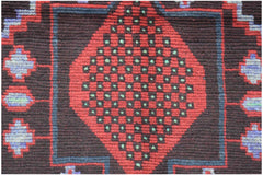 Handmade Afghan wool rug featuring a central red diamond pattern with green accents on a dark field.