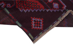 A handmade Afghan Pashm rug featuring geometric tribal patterns in deep red, brown, and blue.
