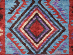 A handmade Afghan Pashm rug featuring a central diamond pattern in red, blue, brown, and ivory.