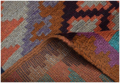 A handmade Afghan Pashm rug featuring a geometric tribal pattern in shades of orange, purple, and blue.