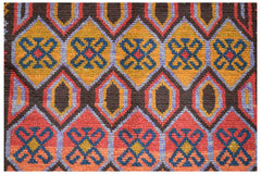 Handmade Afghan Pashm rug featuring a geometric pattern of diamonds in red, orange, and blue.