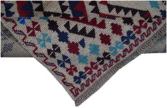 Handmade Afghan Pashm rug featuring a geometric tribal pattern in red, blue, and ivory wool.