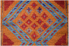 Handmade Afghan wool rug featuring a geometric diamond pattern in red, blue, and orange.