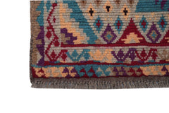 A handmade Afghan Pashm rug featuring a tribal geometric pattern in shades of red, blue, and brown.
