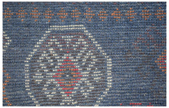 Handmade Afghan Pashm rug featuring a dark blue wool base with geometric ivory and red patterns.